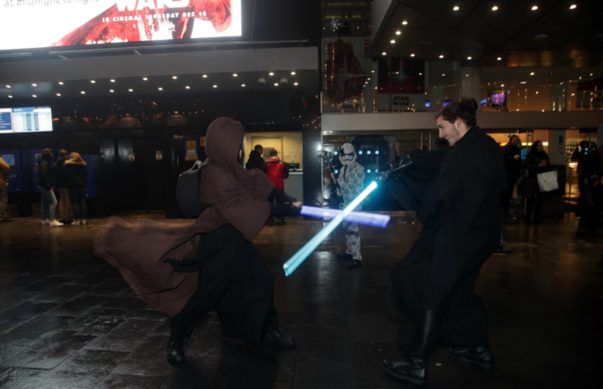 Fans in costume duel with lightsabers
