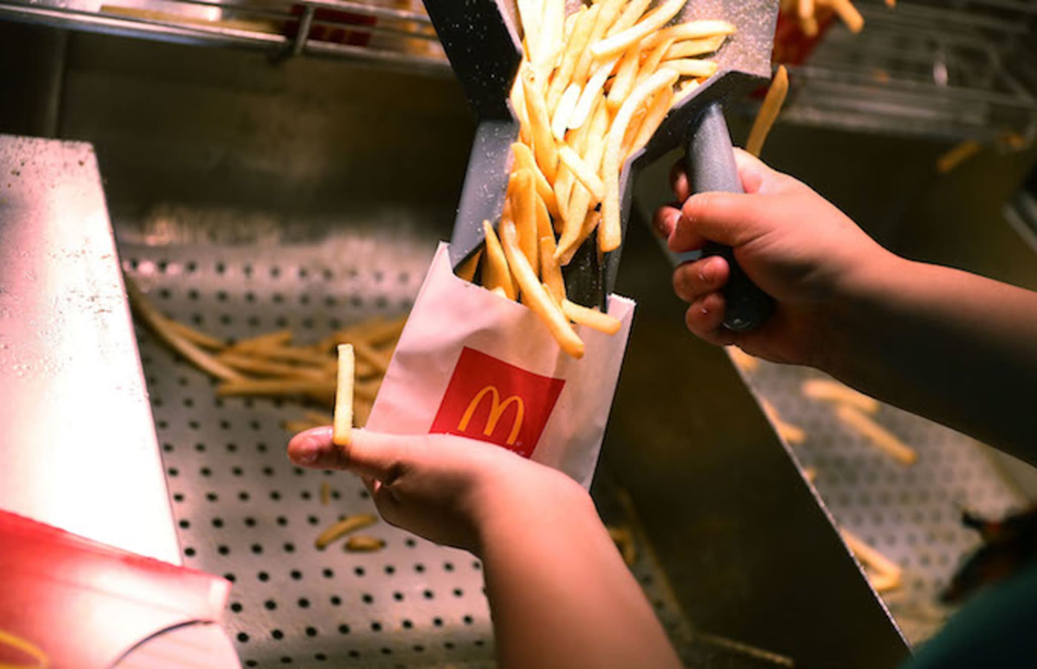 A  McDonald's crew member preparing fries.