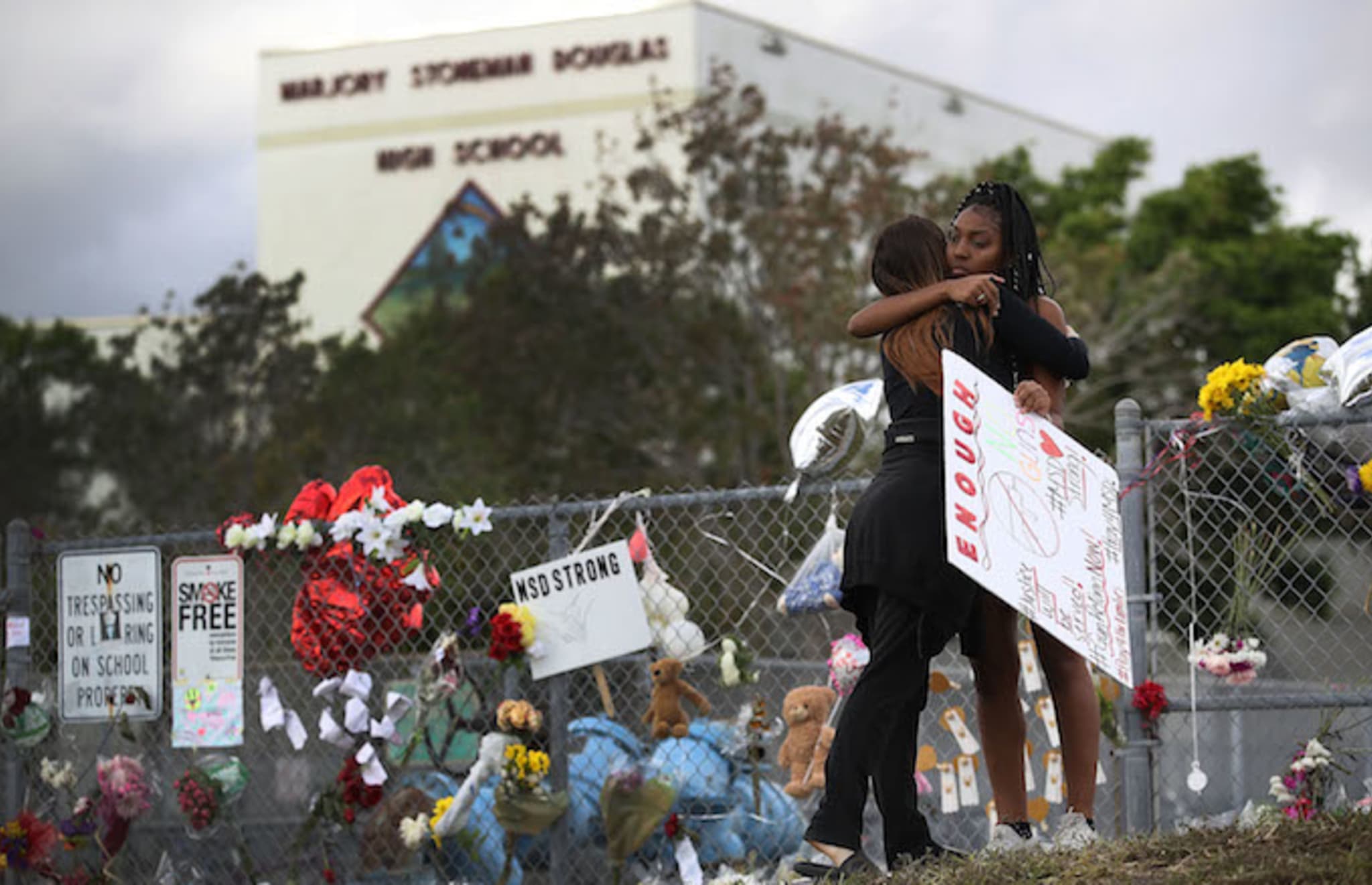 Two  Marjory Stoneman Douglas High School embracing in front of school.