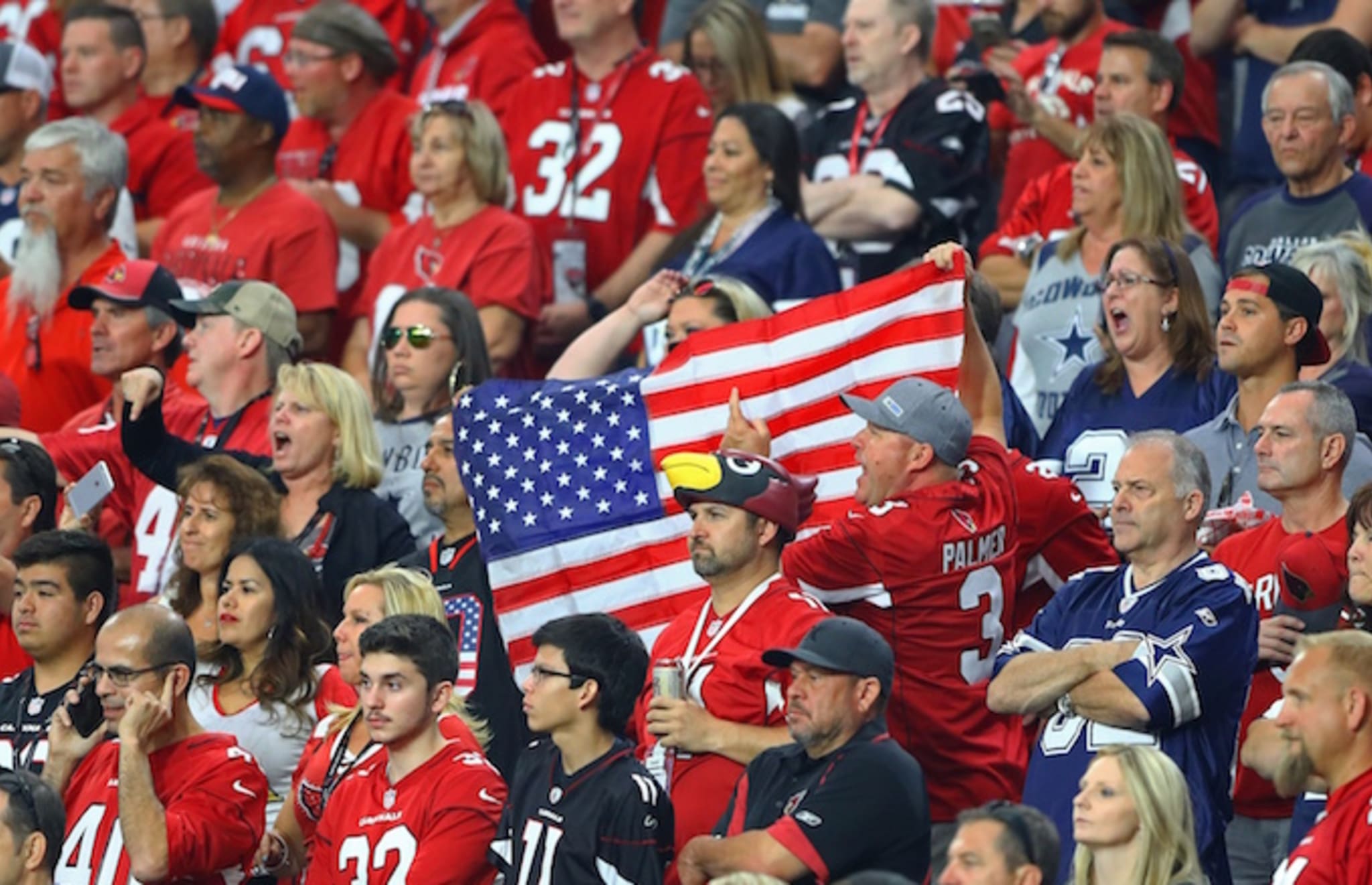 Arizona Cardinals fans hold an american flag.