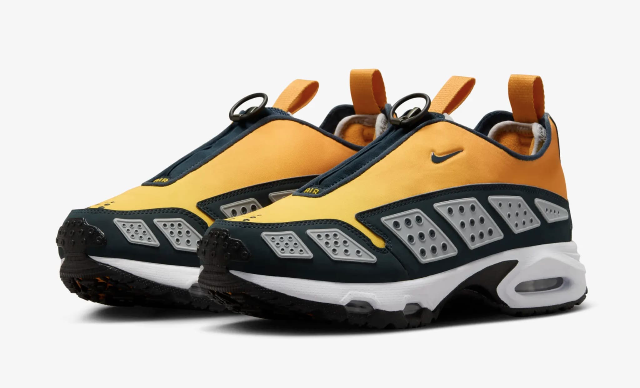 A pair of Nike Air Mada sneakers. The shoes feature a sleek design with breathable panels, a pull tab, and distinctive circular lace loops