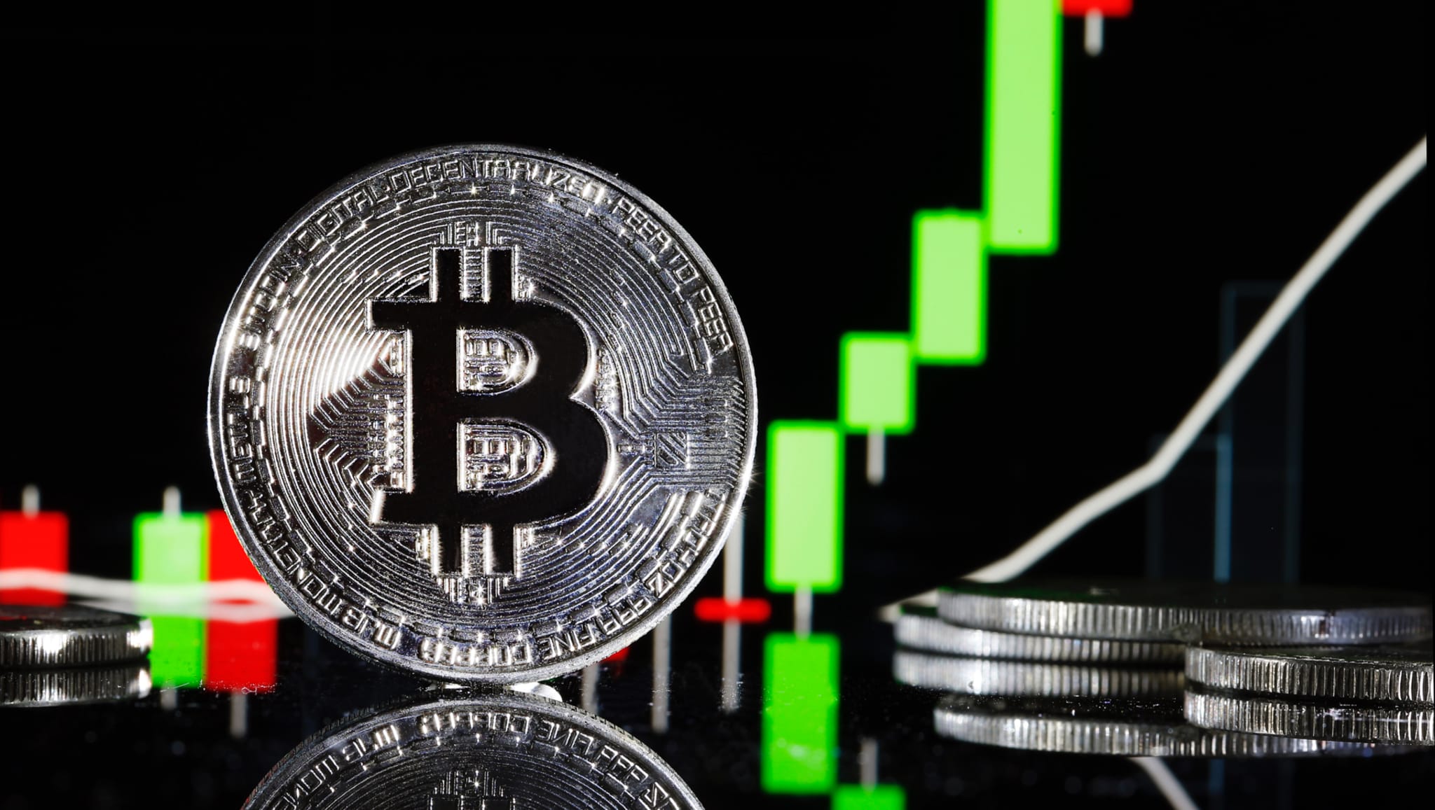 Bitcoin novelty coin in front of trading report