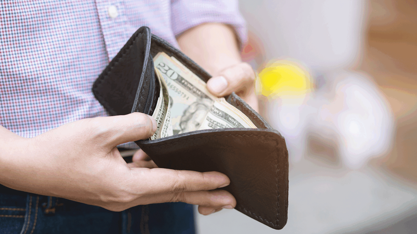 Man opening his wallet to reveal cash.