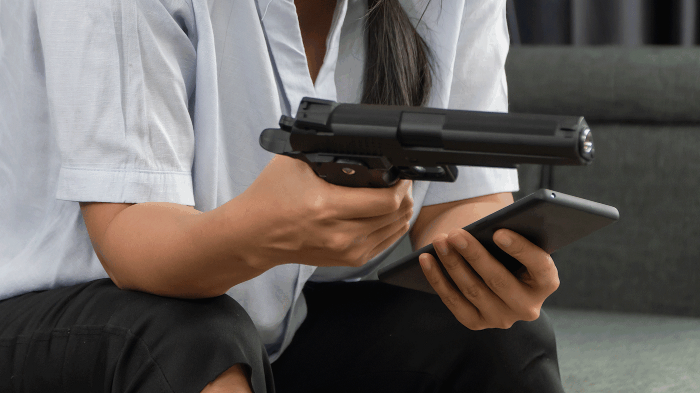 Woman takes selfie with a gun.