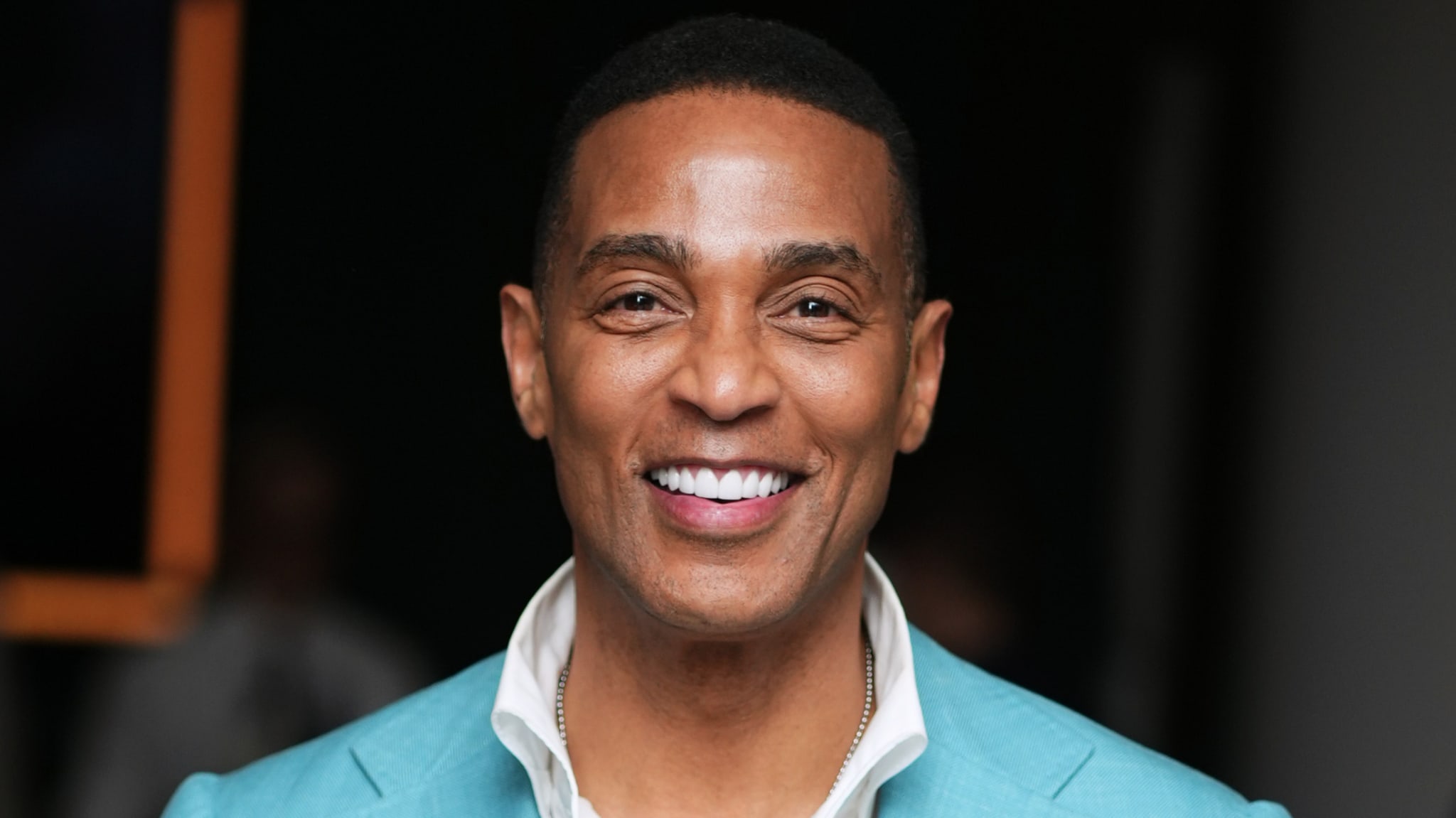 Man smiling in a suit with a white shirt underneath
