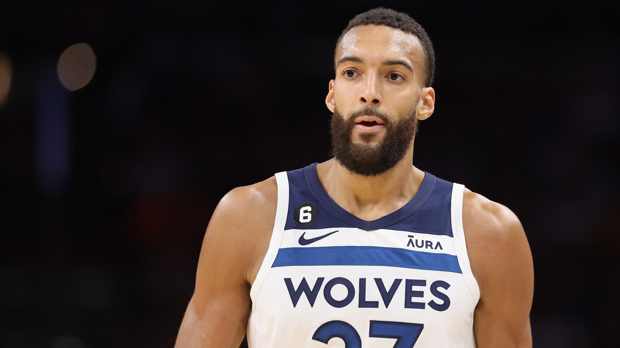 Basketball player in a jersey with "WOLVES 27" on it looks intently during a game