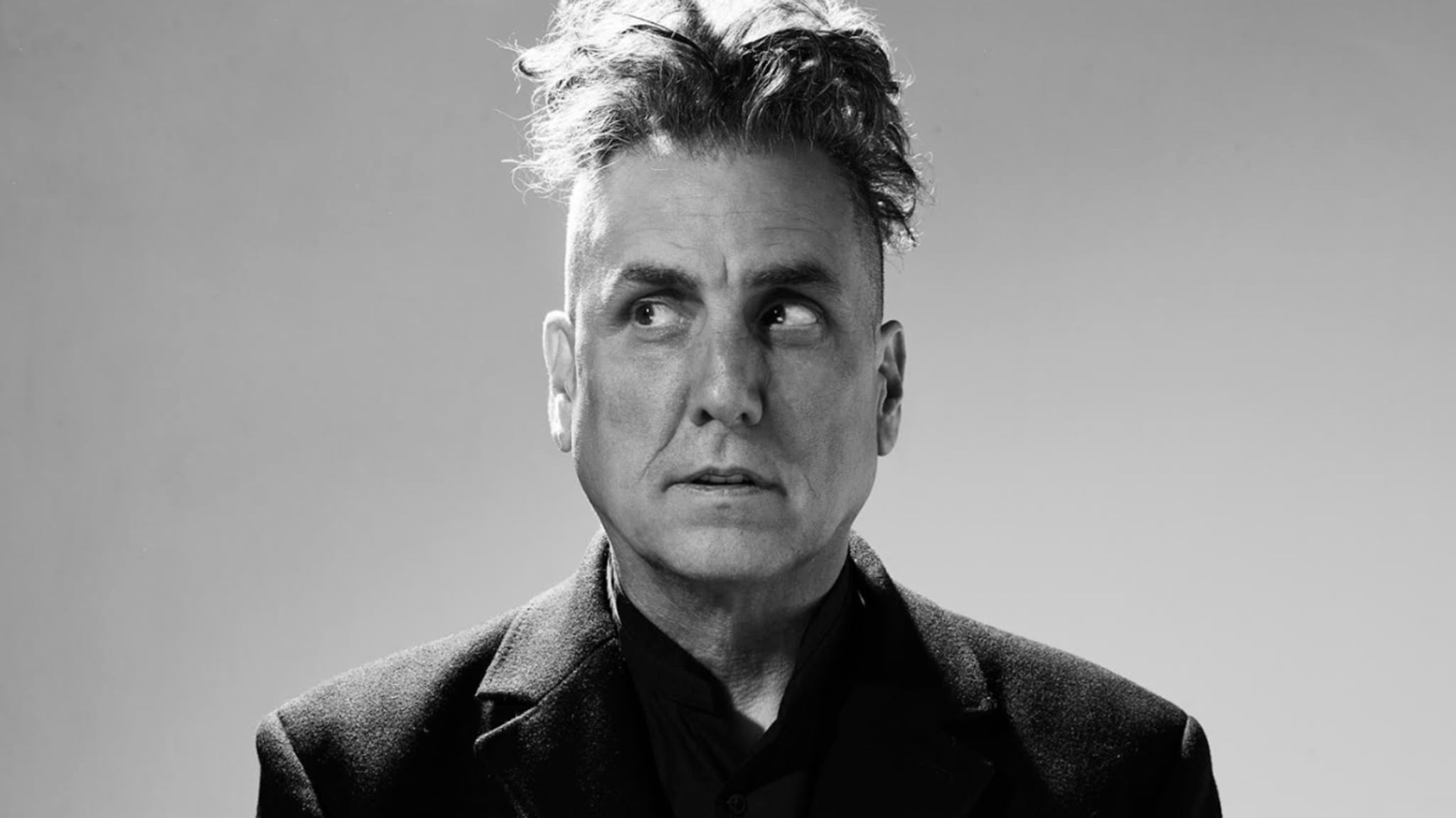 Close-up of a musician in a black jacket with an intense gaze
