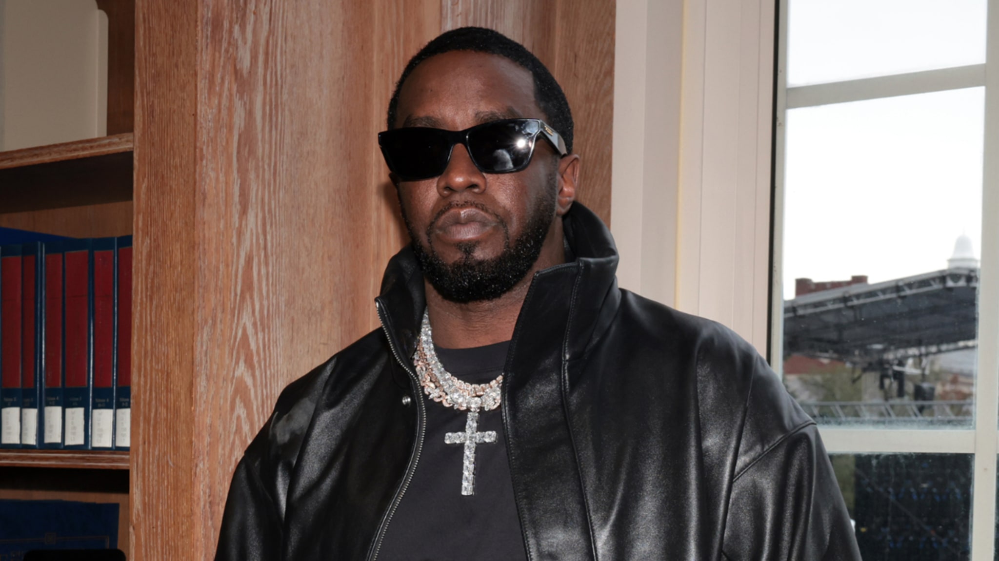 Music artist in black leather jacket and sunglasses with diamond necklace