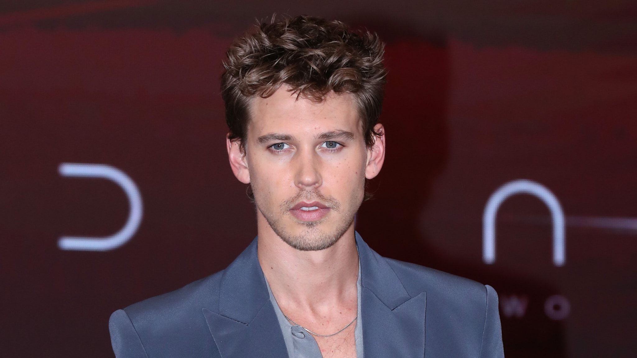 Austin Butler in a gray suit without a tie on the red carpet