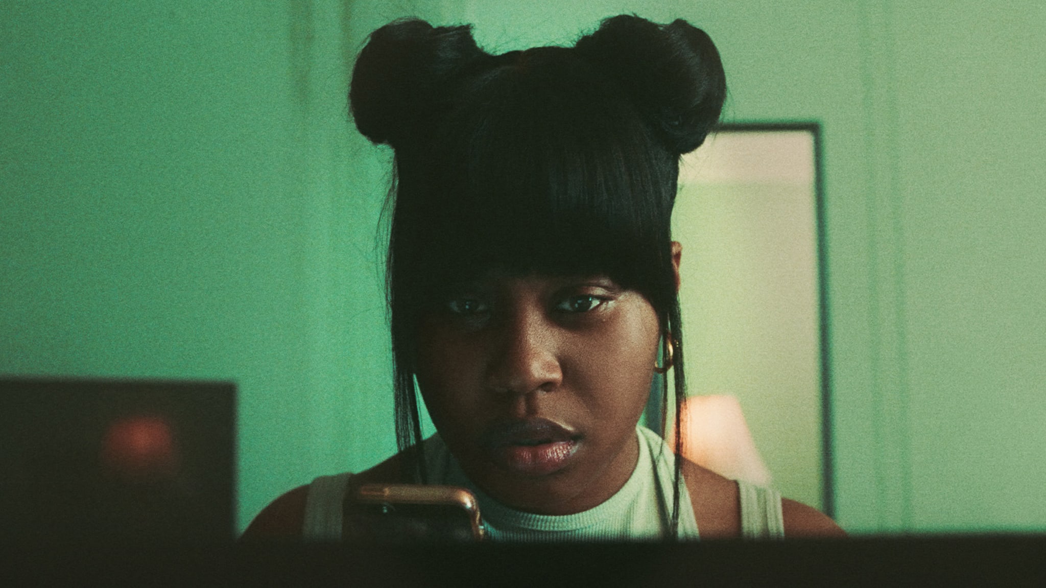Dominique Fishback as Dre stares at a phone on 'Swarm.'