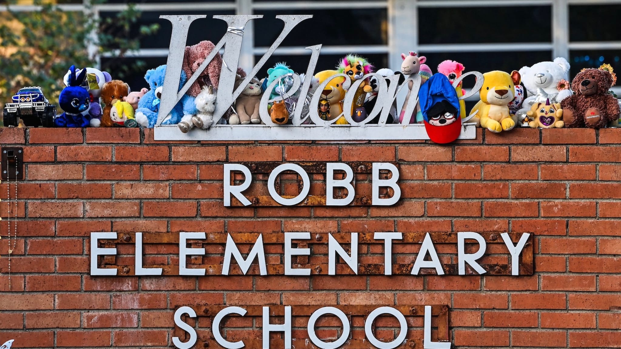 A girl lays flowers at a makeshift memorial at Robb Elementary School