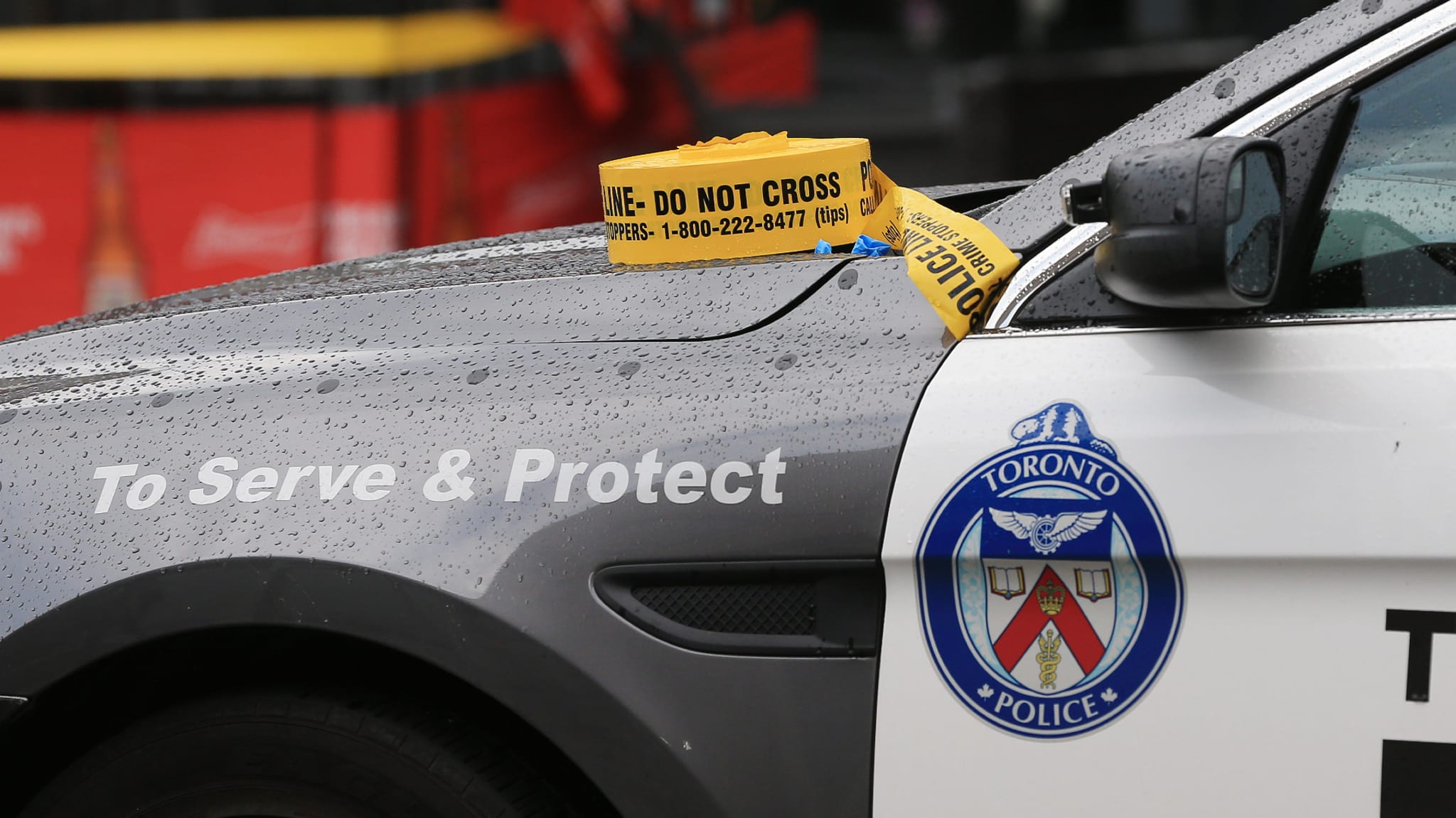 A Toronto Police Services car with caution tape sat on the hood.