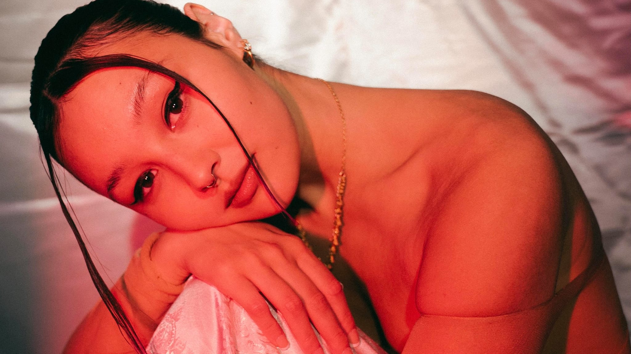 Luna Li sitting in front of a pink sheet