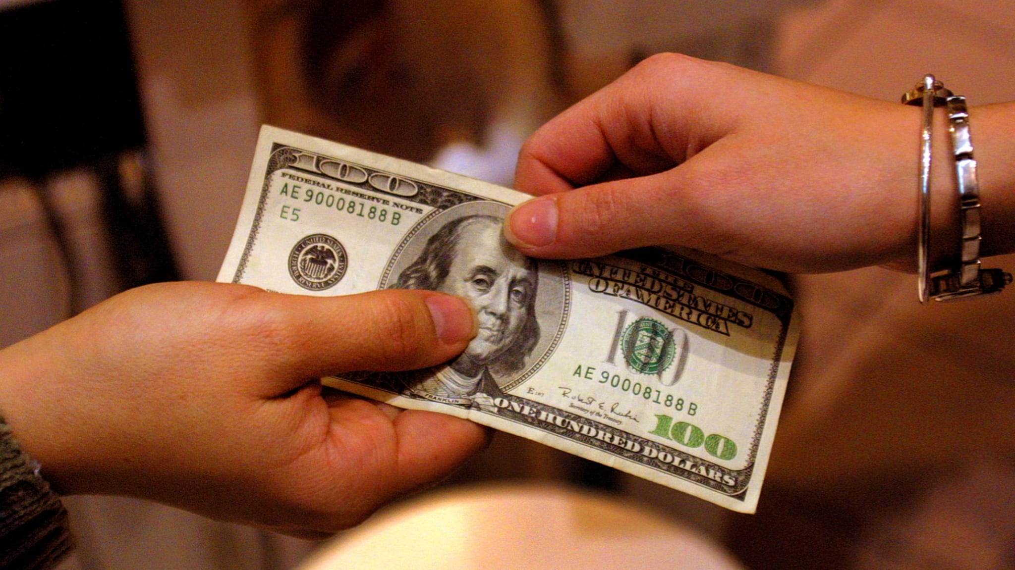 A shopper pays cash for sales merchandise.