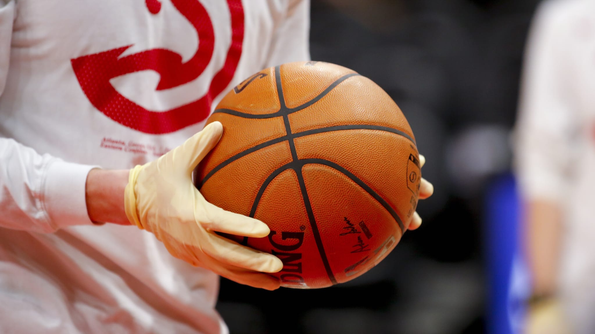 Ballboys wear gloves while handling warmup basketballs