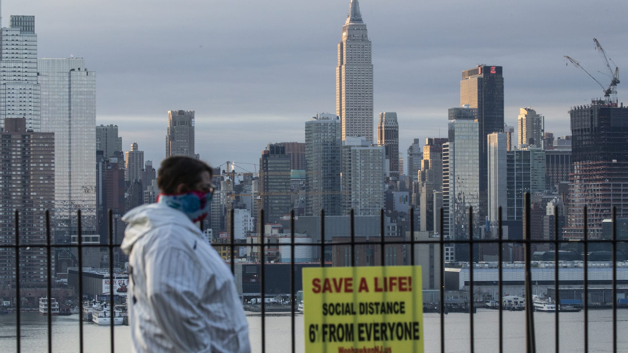 A man covers his face as the sun rises behind in Manhattan