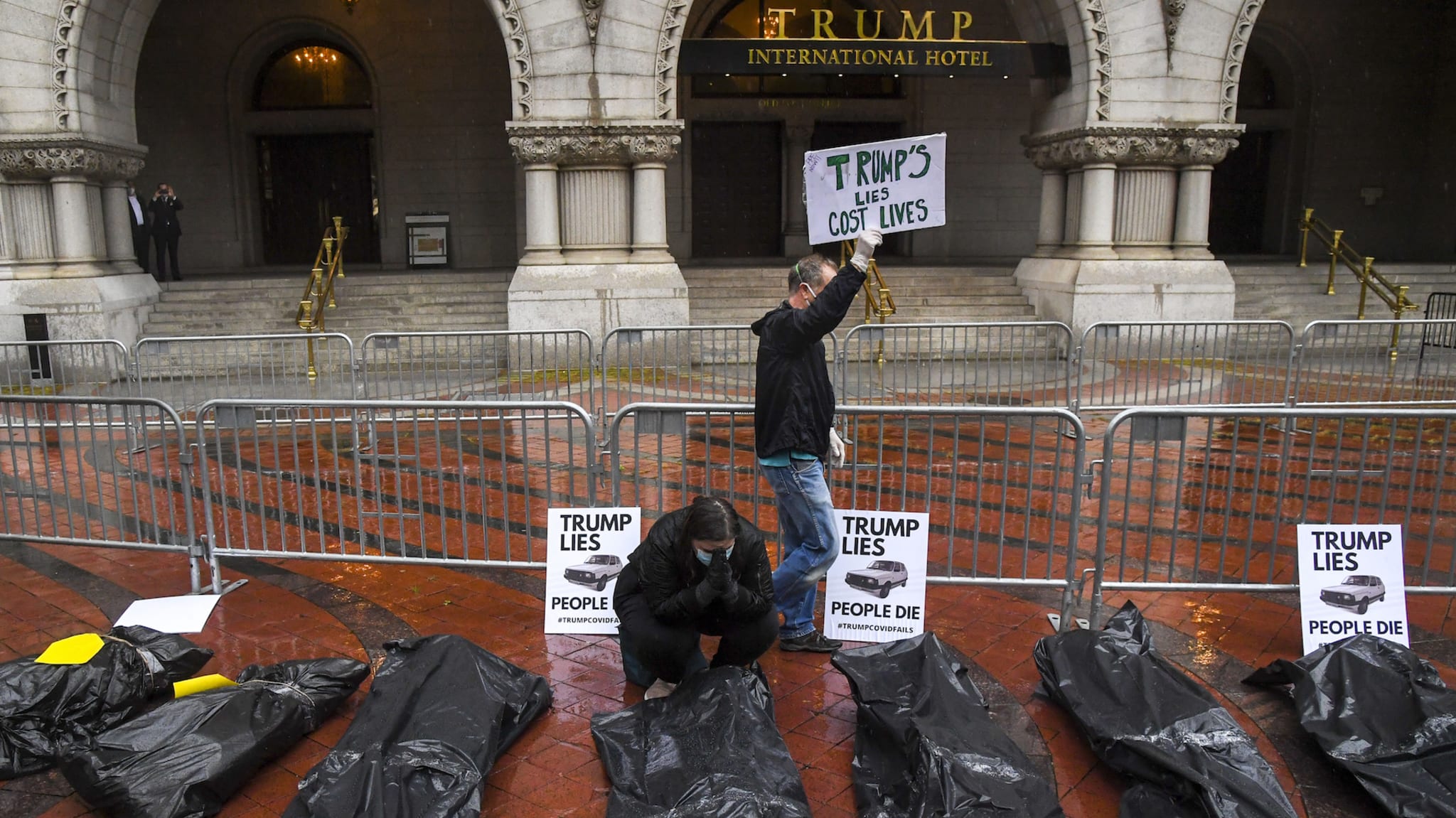 The group calling themselves "The People's Motorcade" , prays in front of the body bags