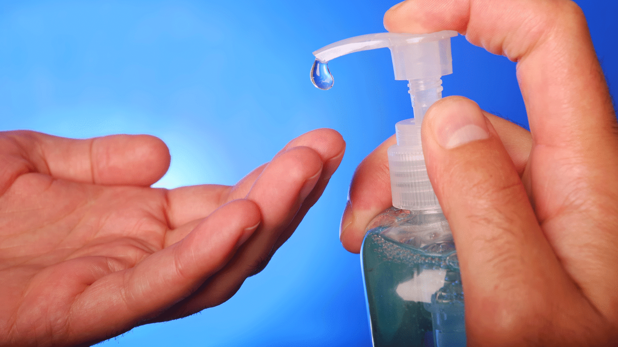 Man squeezes hand sanitizer bottle.