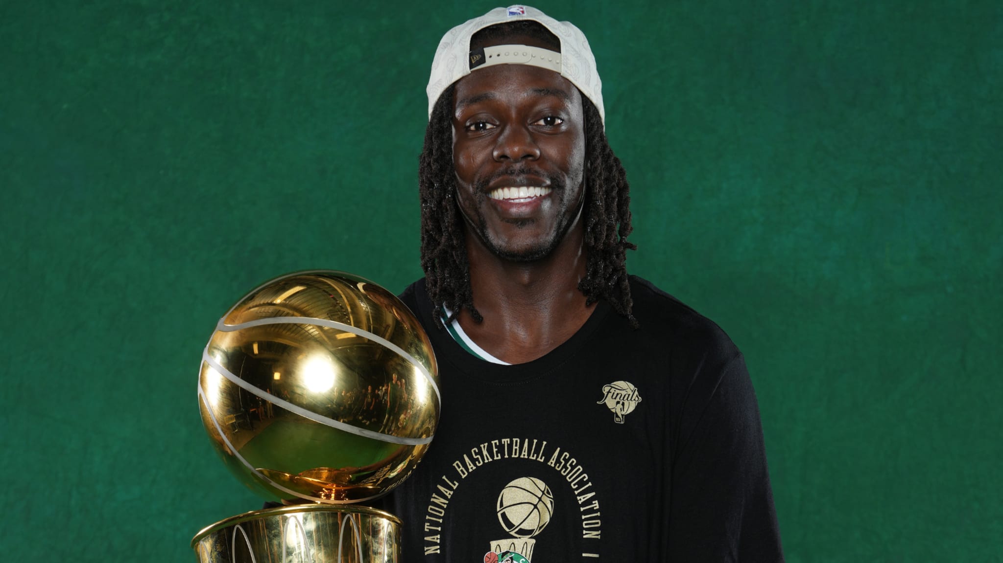 Jrue Holiday holding the Larry O'Brien trophy.