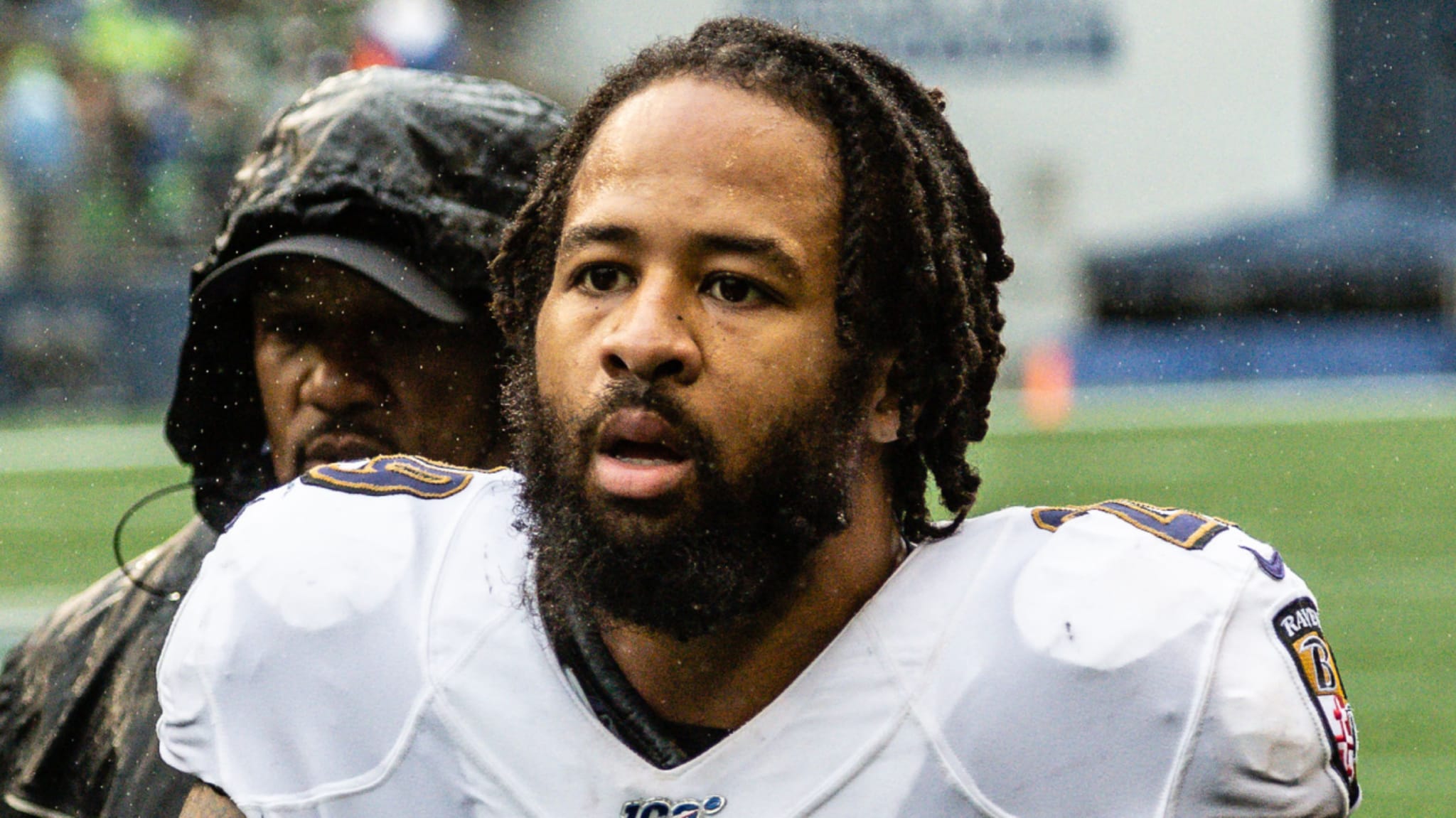 Earl Thomas with dreadlocks and a beard, wearing a Baltimore Ravens jersey, appears focused on the field.