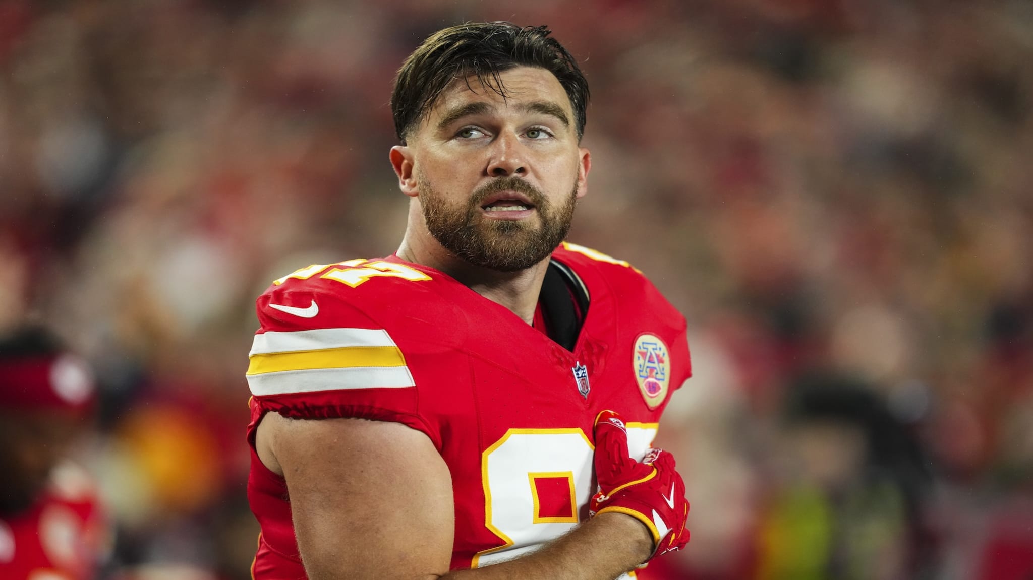 KANSAS CITY, MO - DECEMBER 08: Travis Kelce #87 of the Kansas City Chiefs looks on from the sideline prior to an NFL football game against the Los Angeles Chargers at GEHA Field at Arrowhead Stadium on December 8, 2024 in Kansas City, Missouri.