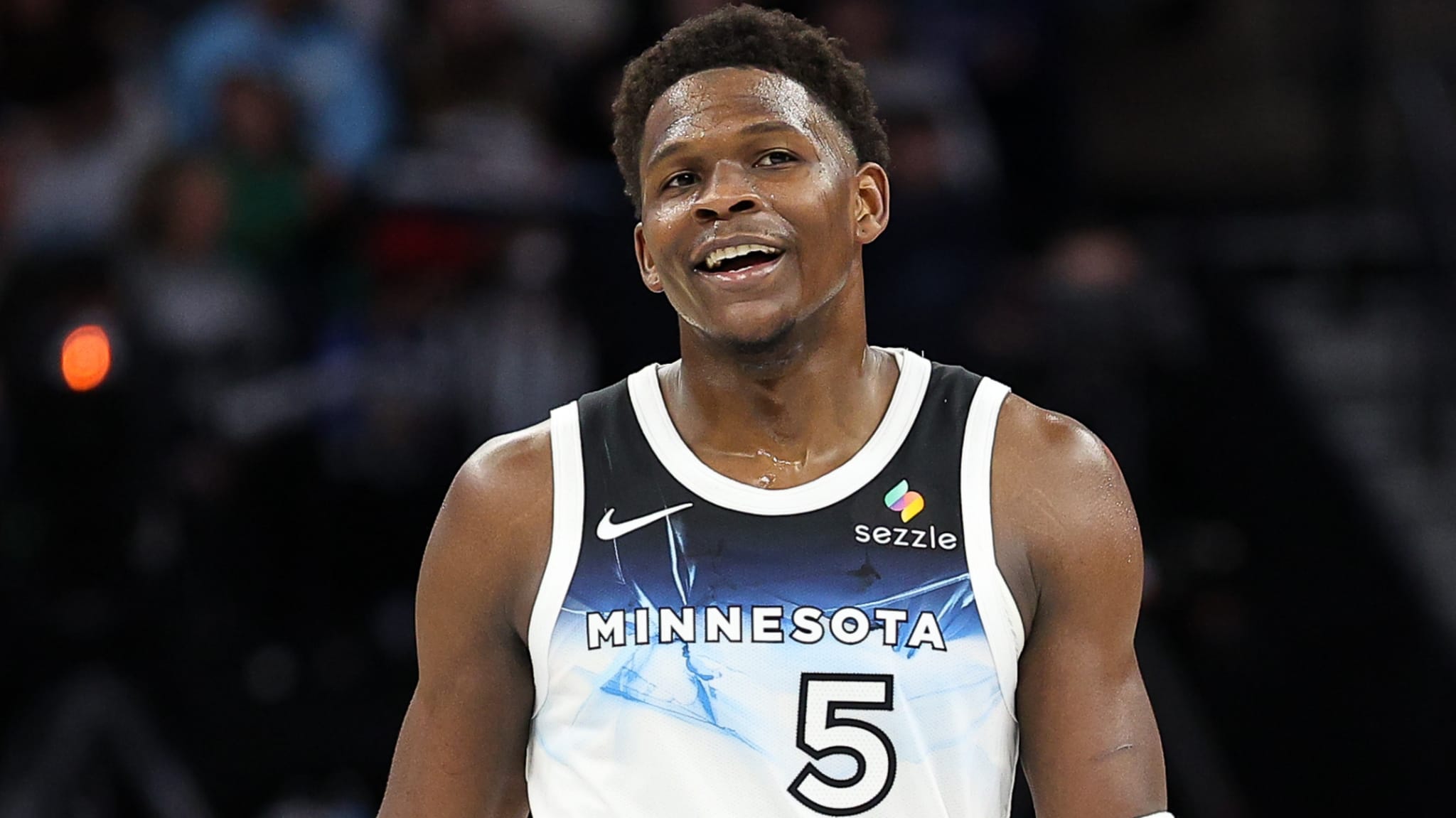 Basketball player in a Minnesota jersey with number 5, smiling during a game.