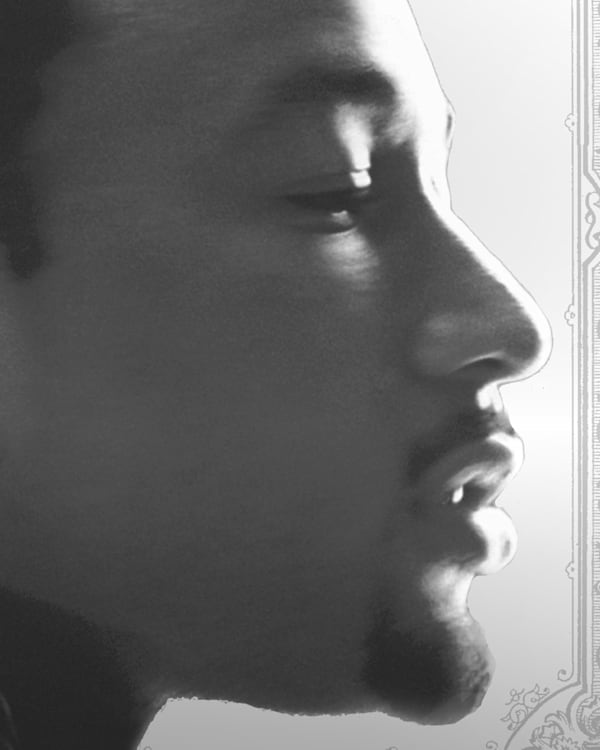 Profile of John Legend in black and white, with ornate border design.