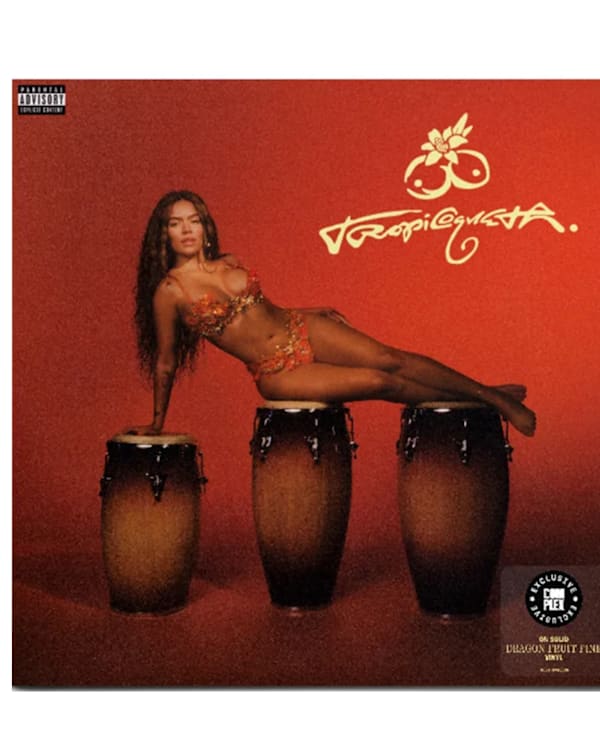 A red vinyl record with an album cover showing Karol G in a floral outfit reclining on three conga drums against a red background.