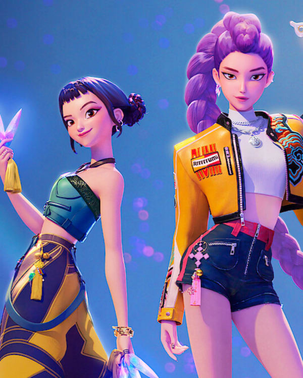 Three animated female characters from the film 'KPop Demon Hunters.' They're wearing colorful outfits and hairstyles pose confidently against a blue background, holding glowing items.