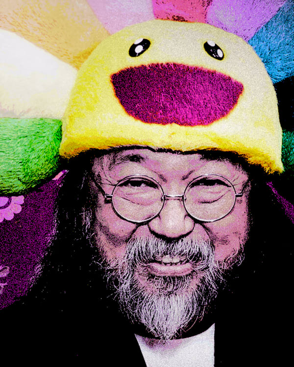 Takashi Murakami wearing a colorful, smiling flower hat with a patterned floral background.