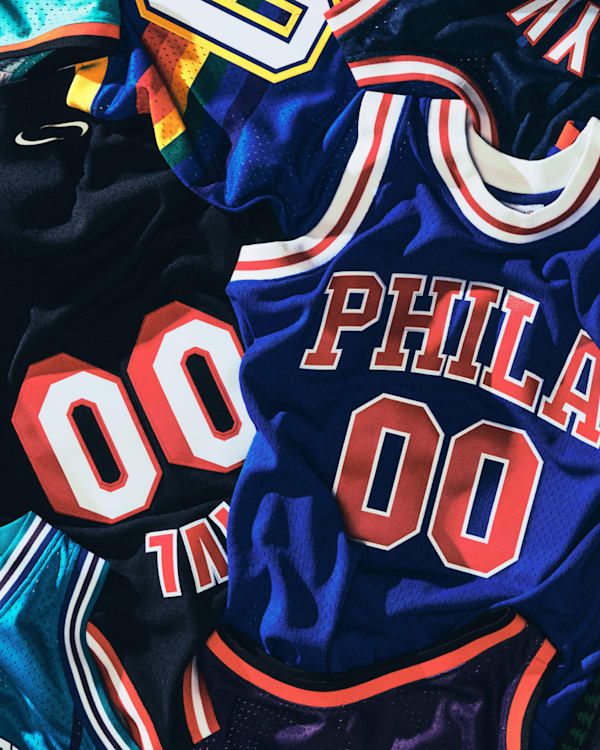 A collection of colorful basketball jerseys with various team names like "PHILA" and "NEW YORK," all featuring the number 00.