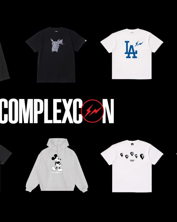 Text "COMPLEXCON" on a textured, metallic rock surface with a lightning bolt in the letter "O," set against a black background.