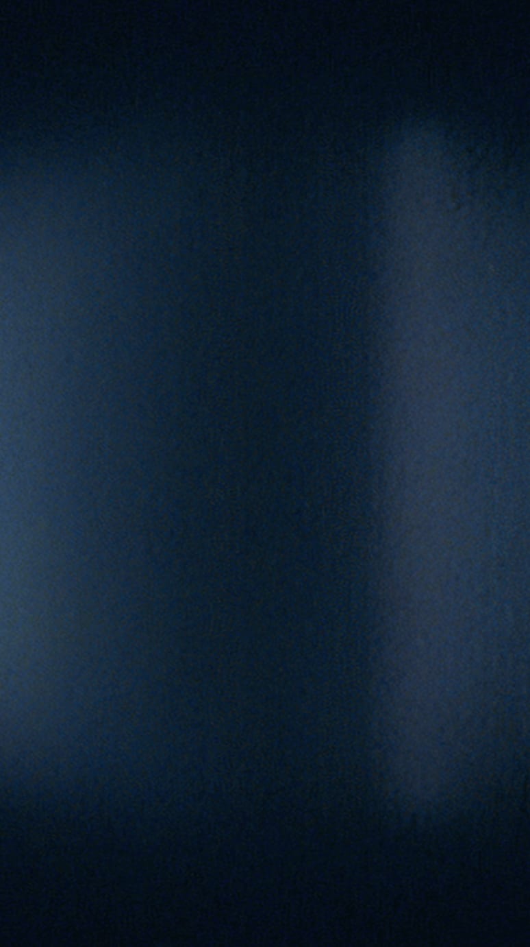 A dark, abstract gradient with shades of blue and black, creating a smooth, textured effect.