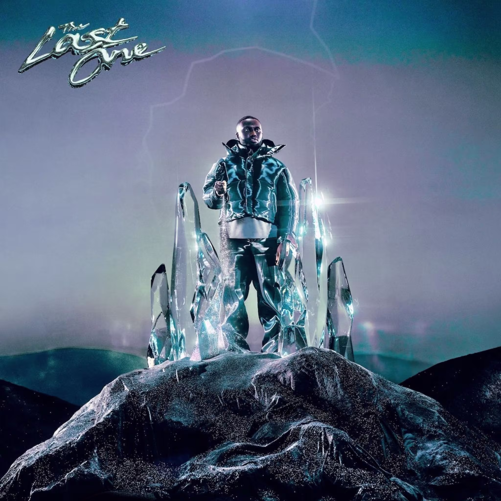 A person stands surrounded by large crystal shapes on a futuristic-looking set. The text "The Last One" is visible in the top left corner. No further text present