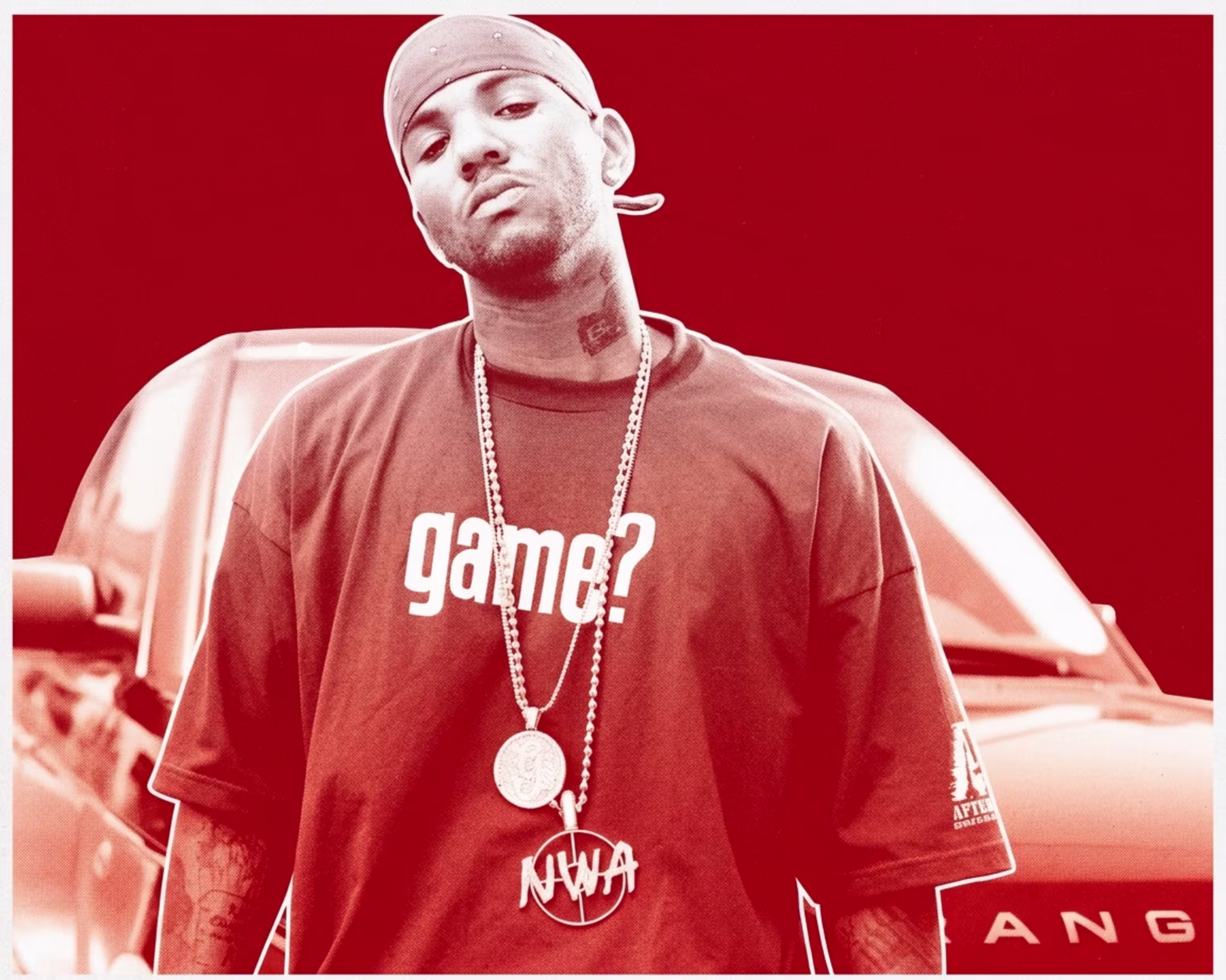 Rapper The Game wearing a bandana and "game?" shirt, standing in front of a car.