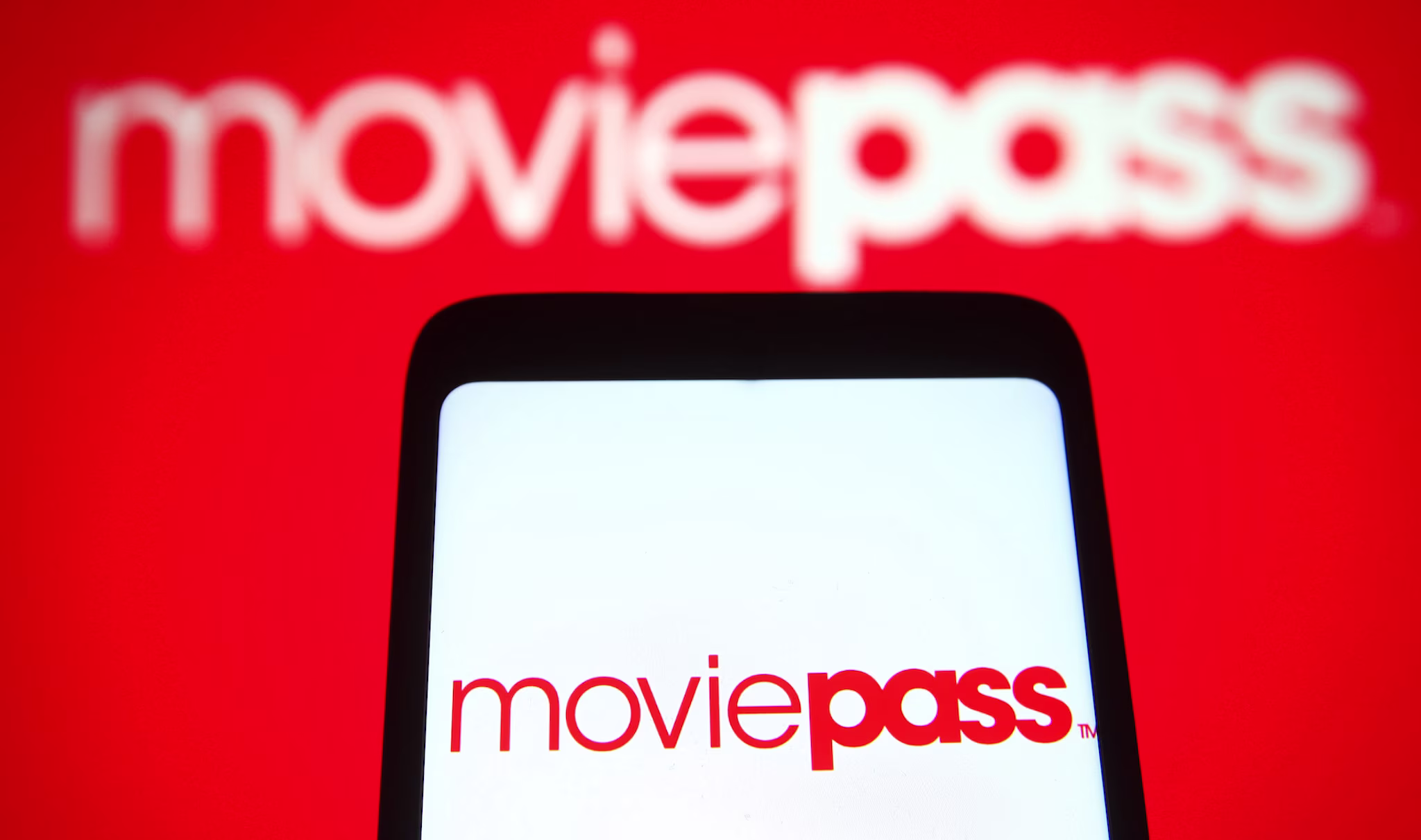 moviepass logo on a cell phone with other logo in back