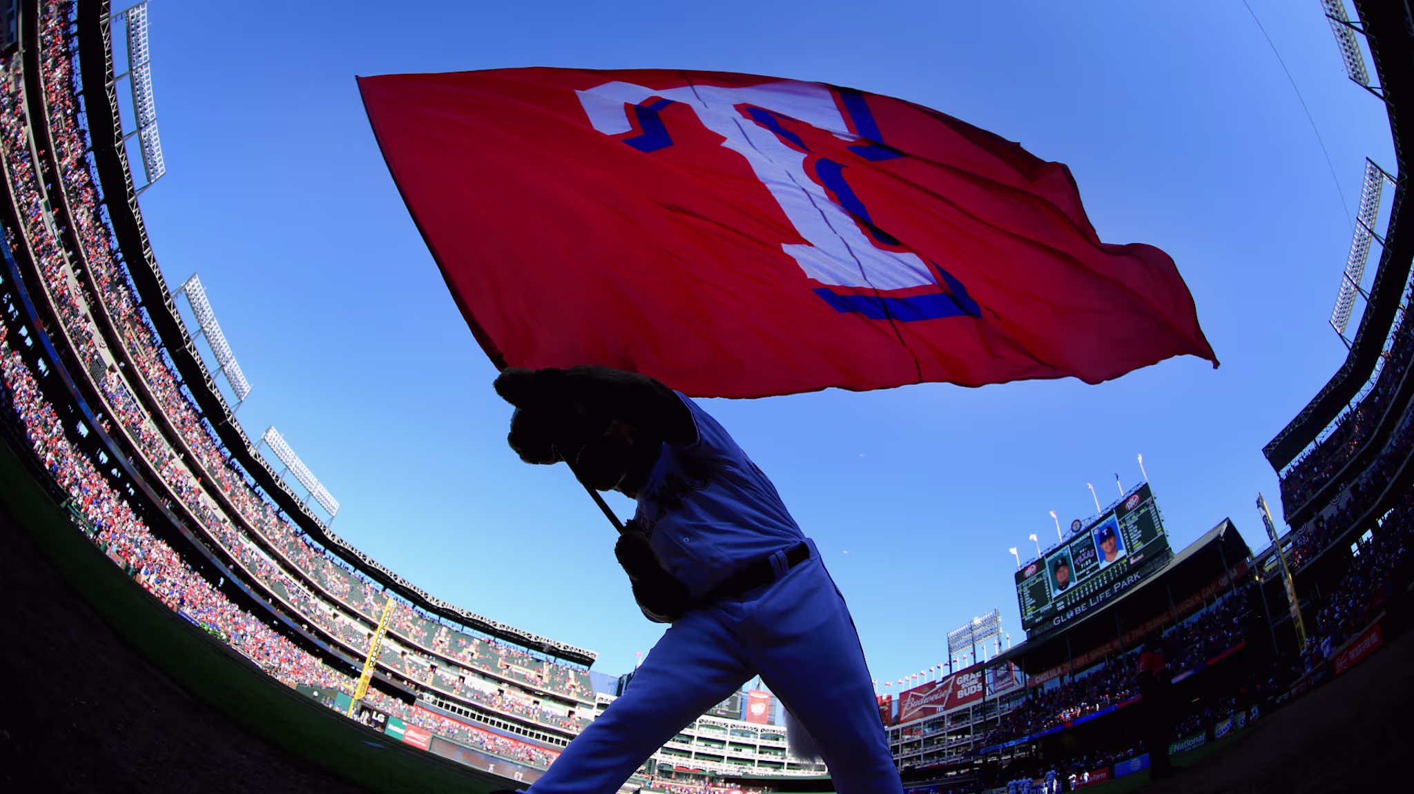 Captain, the Texas Rangers mascot, waves the team flag after the Texas Rangers beat the Seattle Mariners.
