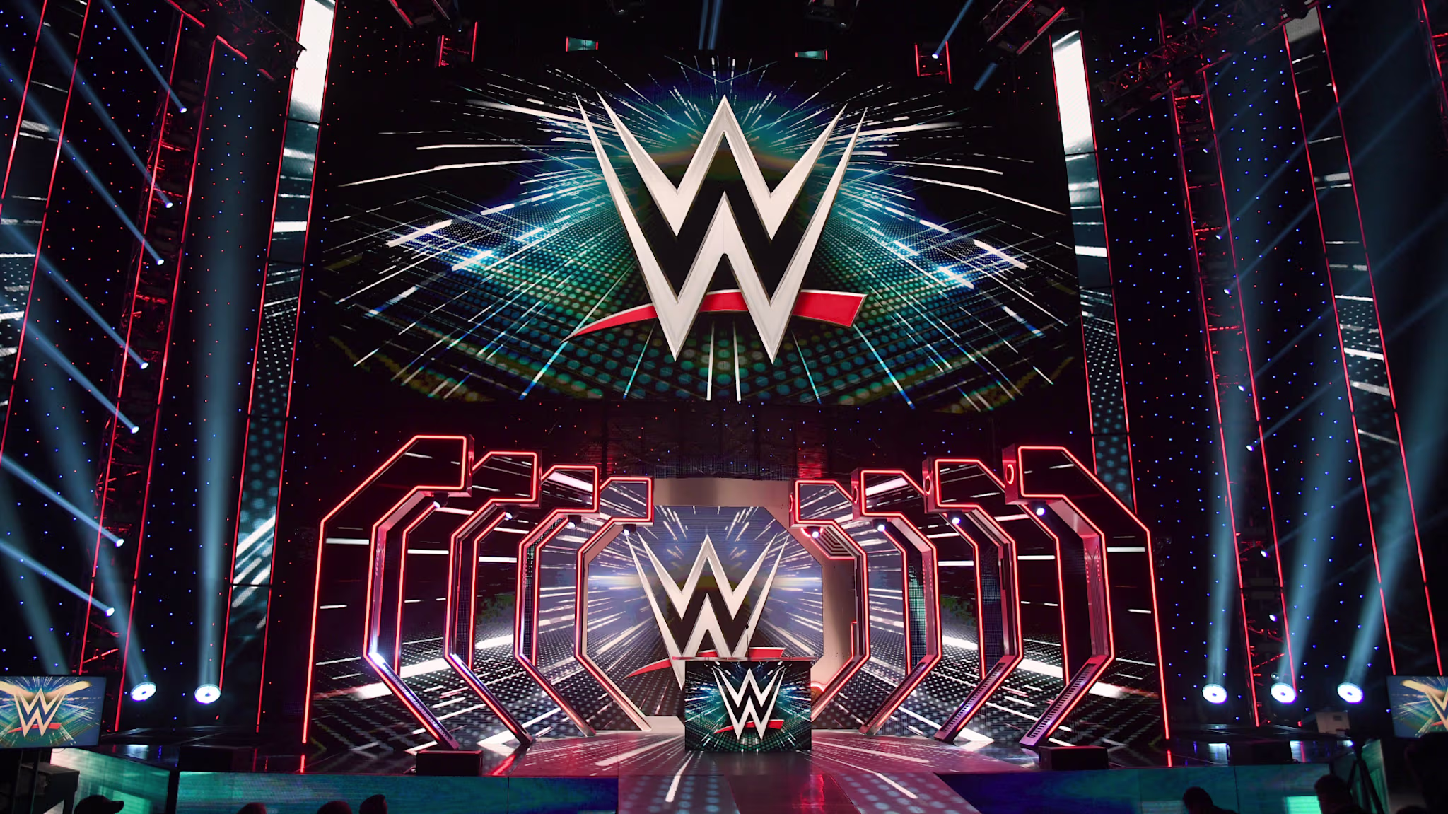 WWE logos are shown on screens before a WWE news conference.