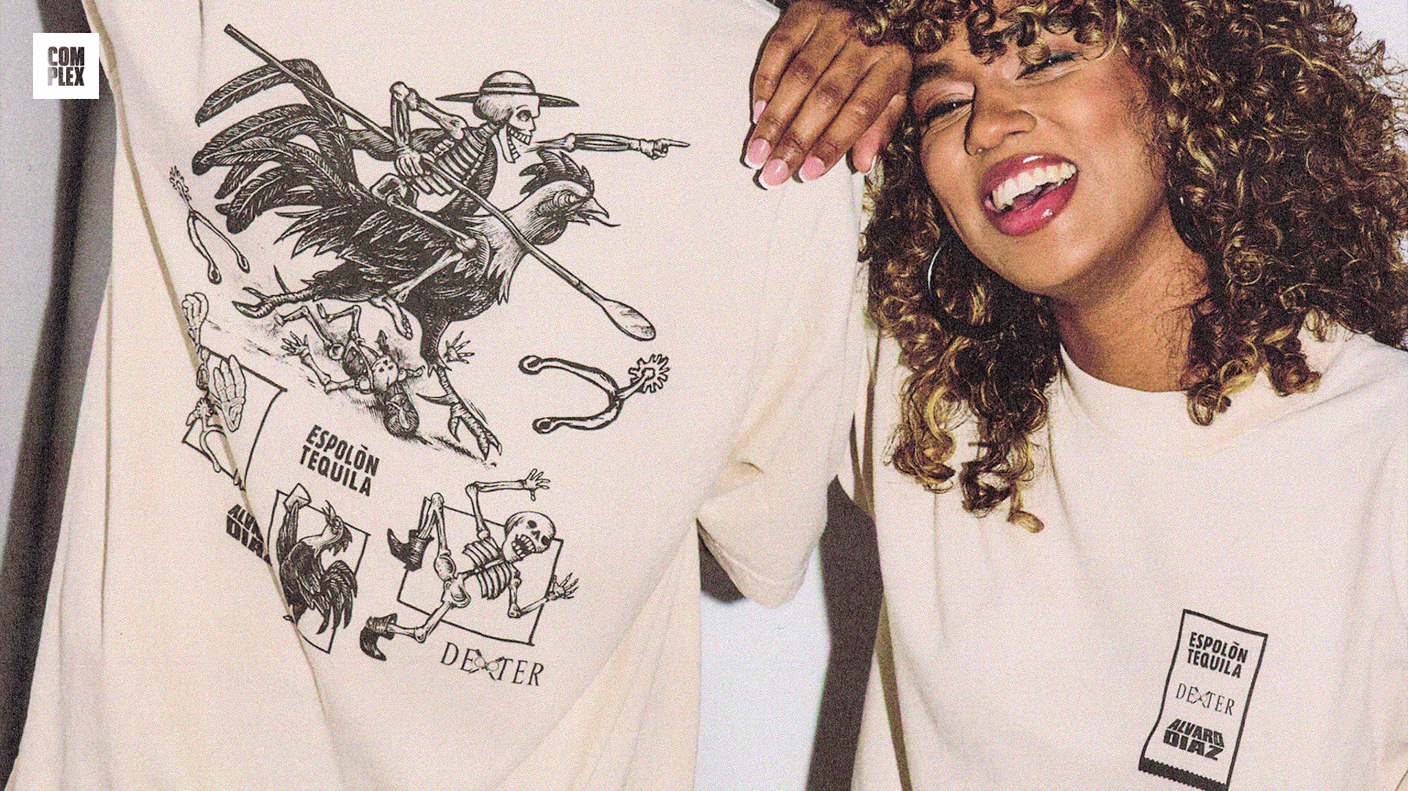 A woman with curly hair smiles, wearing a T-shirt with "Espolón Tequila" and "Dexter" logos. Another person shows a skeleton design on their shirt.