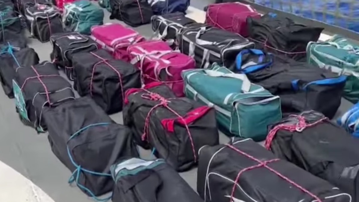 Rows of duffel bags neatly arranged on a surface, secured with string