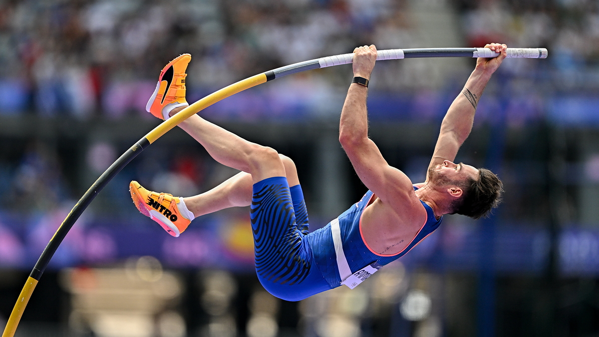 Athlete in mid-air while pole vaulting during a sports event