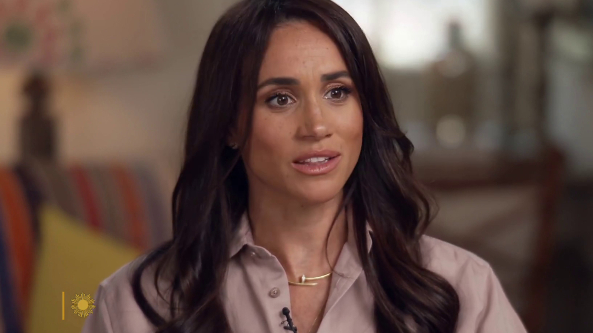 Meghan Markle during an interview, wearing a collared shirt and a delicate necklace