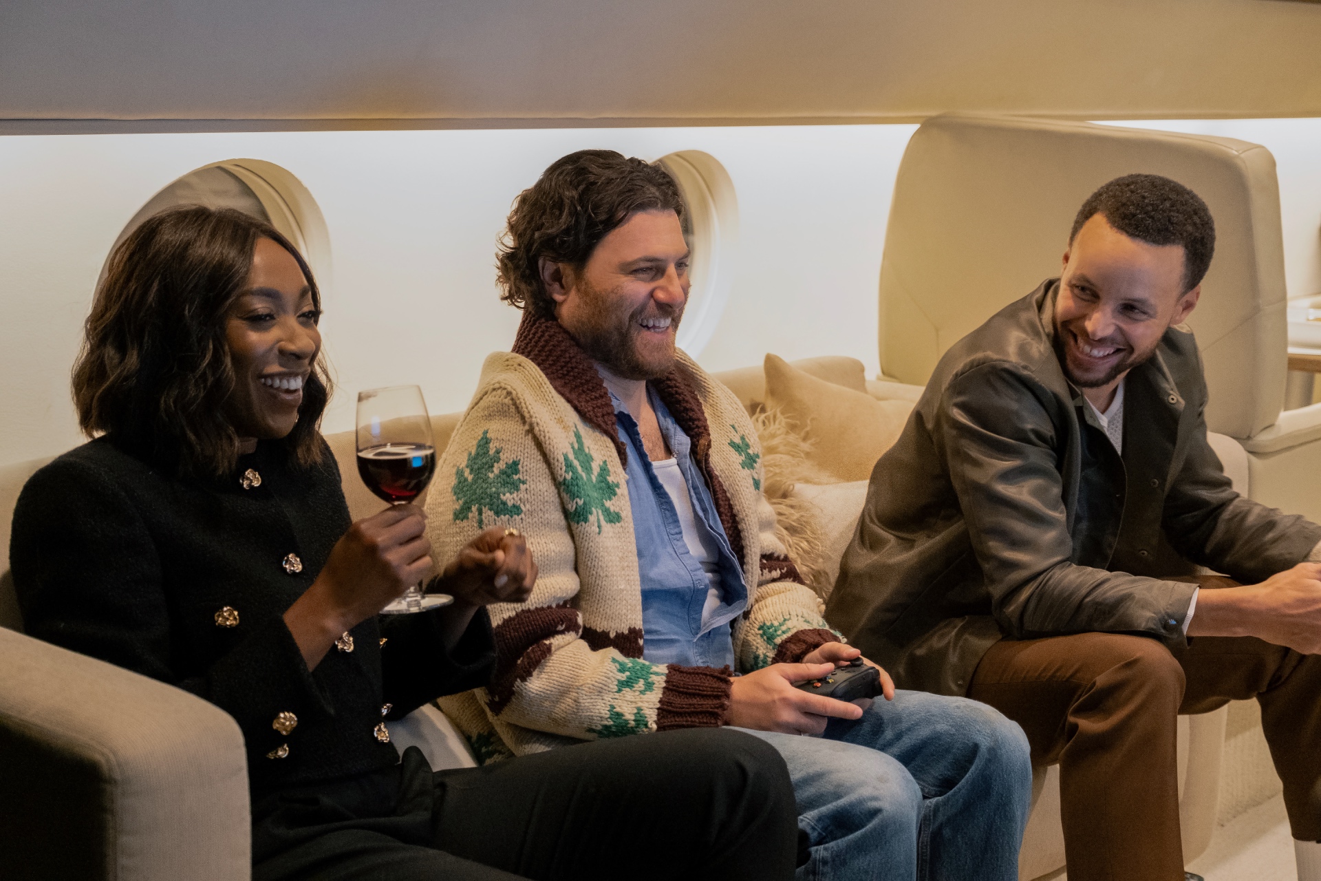 Ego Nwodim (left), Adam Pally (middle), and Steph Curry (right) laugh together on the set of Mr. Throwback.