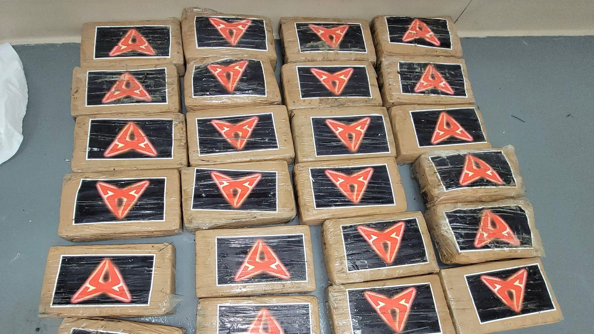 Bundles wrapped in plastic, each with a black rectangular label featuring a red triangular symbol in the center