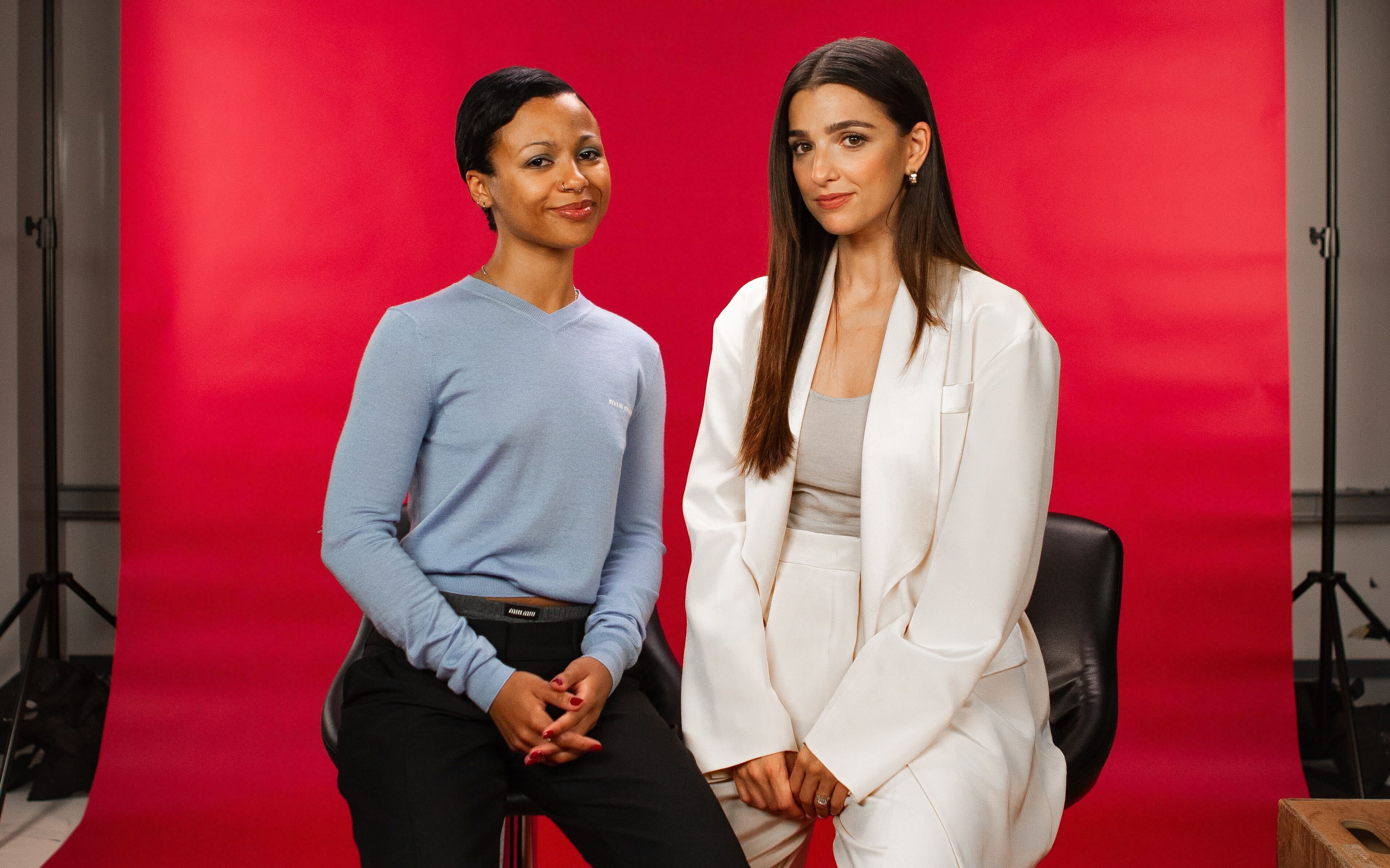 Myha'la (left) and Marisa Abela (right) stand in front of a red backdrop.