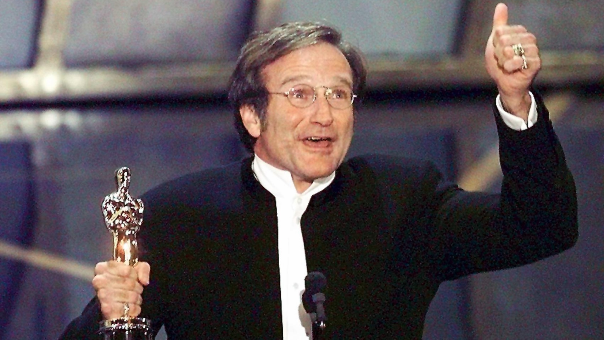 Robin Williams gives a thumbs up while holding an Oscar trophy in March 1998.