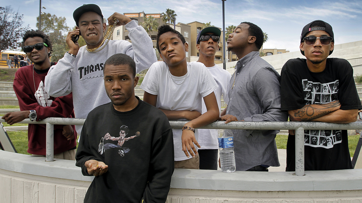 Members of Odd Future standing together outdoors, including Frank Ocean, Tyler, the Creator, Earl Sweatshirt, Syd Tha Kyd, Left Brain, Mike G, and Hodgy Beats