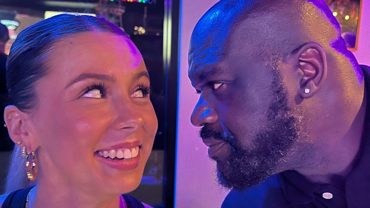 Shaquille O'Neal and Hawk Tuah star share a close, smiling moment, both dressed casually
