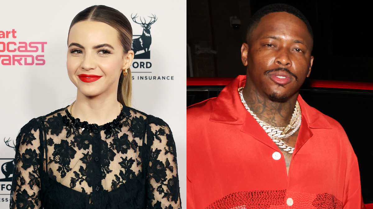 Becca Tobin in a black lace dress and YG in a red shirt with gold chains standing in front of a red car