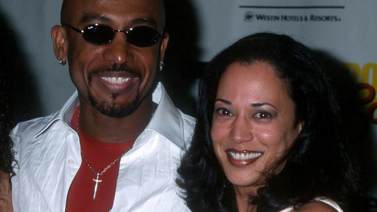 Montel Williams and Kamala Harris, smiling together at a public event. Montel is wearing a white shirt and sunglasses, while Kamala is wearing a white top